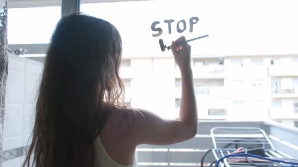 The child writes on the window STOP WAR with a brush and watercolor paint. — Vídeo de Stock
