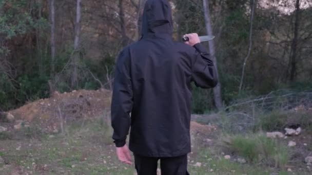 A man with a knife in the forest. The maniac pursues the victim and prepares to attack — Stok video