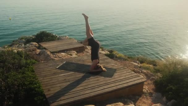 En ung kvinna utövar yoga på havets botten, en sommardag. — Stockvideo