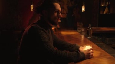 Bir gece barında genç bir adamın portresi. Bir adam kokteyl içer ve barmenle iletişim kurar..