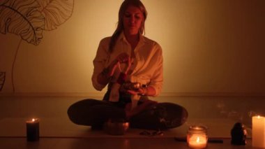 Elinde Tibet şarkı kasesi olan Yogi bir kadın. Yoga odasında..