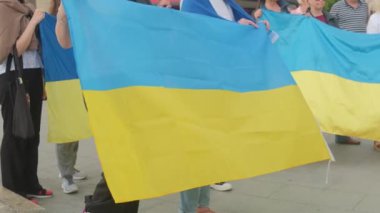 Savaşa karşı düzenlenen mitingde kadınlar Ukrayna bayrağını tutuyor.