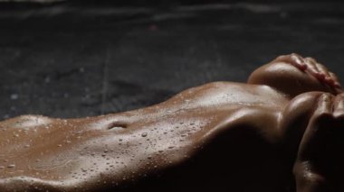 Siyah bir arka planda bronzlaşmış güzel bir vücut. Süt kızın vücuduna dökülüyor..