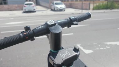 Tarragona, İspanya - 12 Haziran 2022: Elektrikli scooter kiralamak için akıllı telefonlu bir QR kodunu taramak.