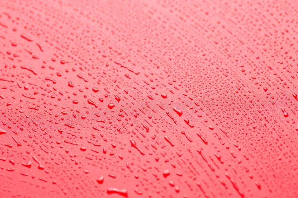 Red waterproof cloth covered with water drops