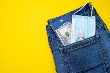 Kotlu pasaport parası ve koruyucu maskeli bir cep. Pandemik seyahat kavramı.