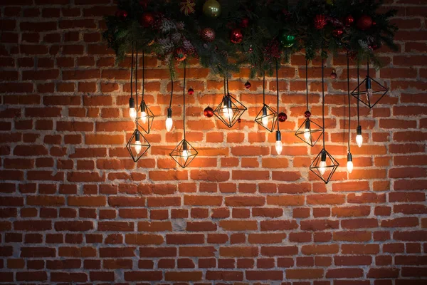Brick wall with light bulbs and New Years decoration.