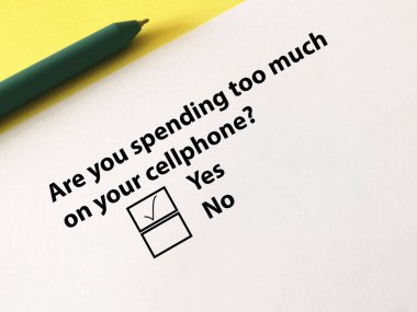 Bir kişi soruya cevap veriyor. Cep telefonuna çok para harcadığını düşünüyor..