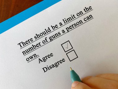 One person is answering question about firearm. The person agrees that there should be a limit on the number of guns a person can own.