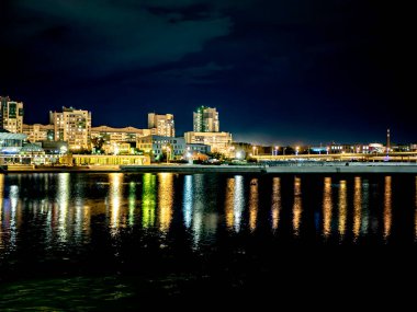 Sirk alanındaki Chelyabinsk şehrindeki Miass Nehri 'nin gece kıyısında suya, Rusya' ya ve Güney Urallar 'a çok renkli ışıklar yansıyor.