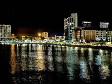 Sirk alanındaki Chelyabinsk şehrindeki Miass Nehri 'nin gece bankası suya, Rusya' ya, Güney Urallar 'a çok renkli ışıklar yansıyor.