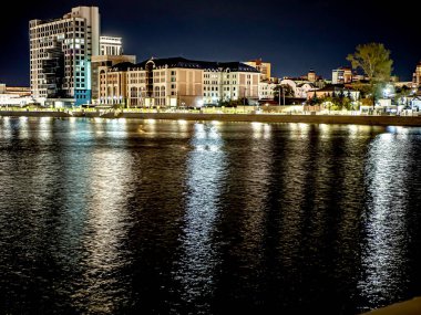 Sirk alanındaki Chelyabinsk şehrindeki Miass Nehri 'nin gece bankası suya, Rusya' ya, Güney Urallar 'a çok renkli ışıklar yansıyor.