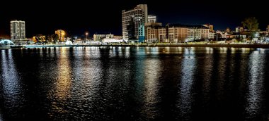 Sirk yakınlarındaki Chelyabinsk şehrindeki Miass Nehri 'nin panoramik manzarası suya, Rusya' ya ve Güney Urallarına renkli ışıklar yansıyor.