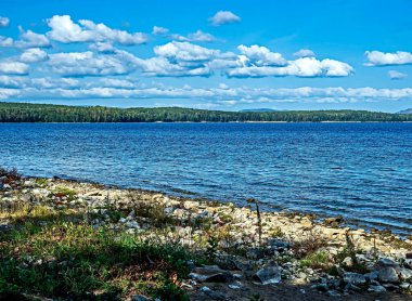 Göl üzerinde beyaz bulutlu mavi gökyüzü