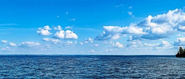 Göl üzerinde beyaz bulutlu mavi gökyüzü