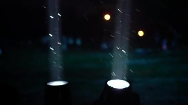 Geceleyin sahne ışıkları, kar yağışı sırasında kar taneleri ışığa doğru dönüyor.