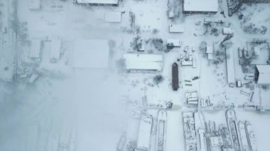 Endüstriyel bölgeden ısı güç şebekesinin borusuna uçun. Buz içinde donmuş suyla dolu bir yükleme rıhtımı olsun. Şehrin arka planında duman bulutları.