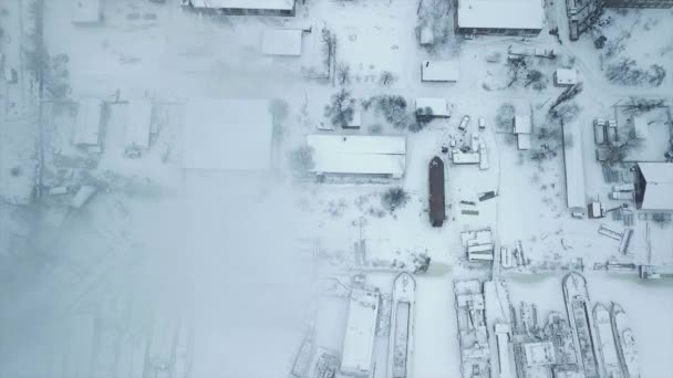 Vlucht over de industriezone naar de leiding van het warmtenet met een laadperron met bevroren water in ijs. Rookpluimen tegen de achtergrond van de stad. — Stockvideo