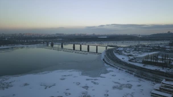 10 lutego Ukraina Kijów, most kolejowy. Widok z wysokości lotu, przy zachodzie słońca na zimowy krajobraz. — Wideo stockowe