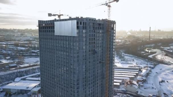Neem de camera mee een gebouw in aanbouw met lege plafonds in het contrasterende licht van de winterzon. — Stockvideo