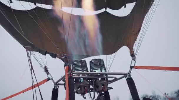 Фестиваль воздушных шаров, вечерняя зимняя горелка наполняет воздушный шар теплым воздухом крупным планом — стоковое видео