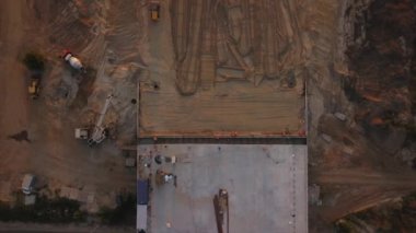Construction machinery at work levels the surface with sand at the construction site, bridge construction, interchanges across the road, top view. High quality FullHD footage
