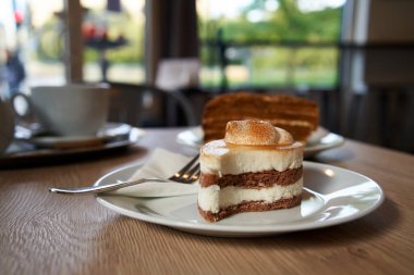 Tarçınlı tatlı. Kafede bir masa. Arka planda bir fincan çay.