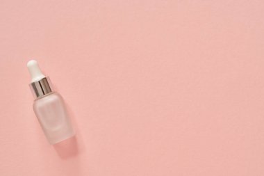 Bir şişe aromaterapi pastel pembe arka planda gerekli yağ ve fotokopi alanı.