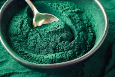 Mavi yeşil spirulina alg tozu kasede kaşık üzerinde, yakın plan.