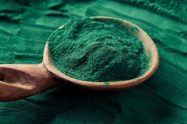 Tahta kaşıkta yeşil spirulina tozu - sağlıklı besin takviyesi