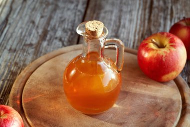 Masanın üzerinde bir şişe elma sirkesi.
