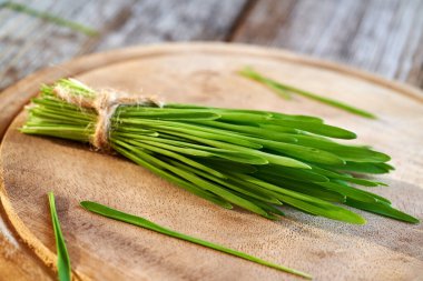 Masanın üzerinde taze yetişmiş yeşil arpa otu. Sağlıklı besin takviyesi.