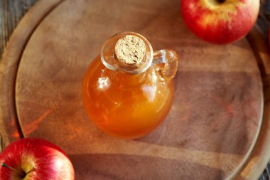 Bir şişe elma sirkesi, taze meyve ve fotokopi alanı.