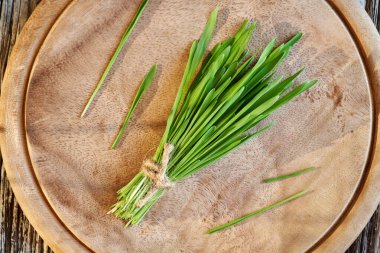 Masanın üzerinde taze yetişmiş yeşil arpa otu. Sağlıklı besin takviyesi.