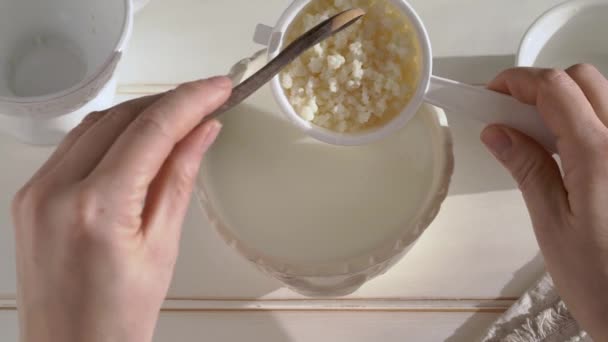 新鮮な牛乳にケフィア粒を入れる 自家製プロバイオティクスドリンクの準備 — ストック動画