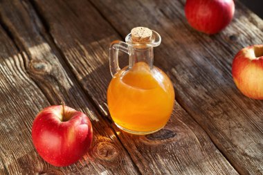 Güneş ışığında kırsal bir masada elma sirkesi şişesi.