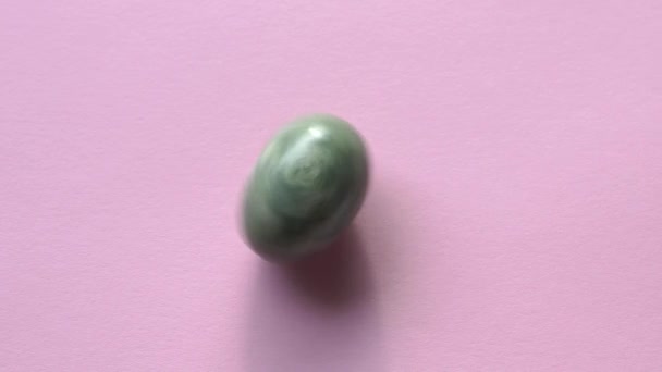 Jade Egg Spinning Pastel Pink Background — стоковое видео