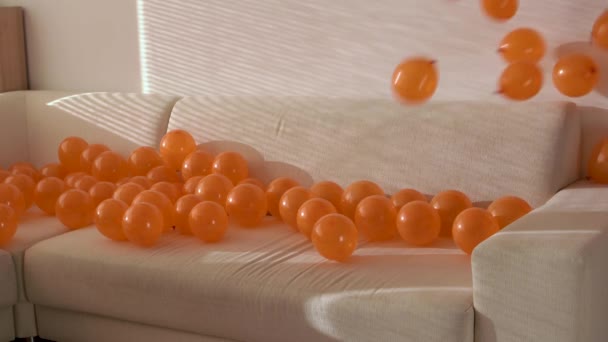Pomarańczowe Balony Spadające Sofę Wewnątrz Mieszkania — Wideo stockowe