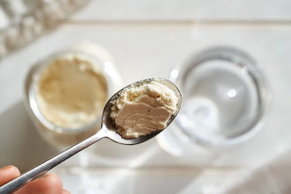 一杯水之上的一汤匙乳清蛋白质粉 健康降饮料的配制 — 图库照片