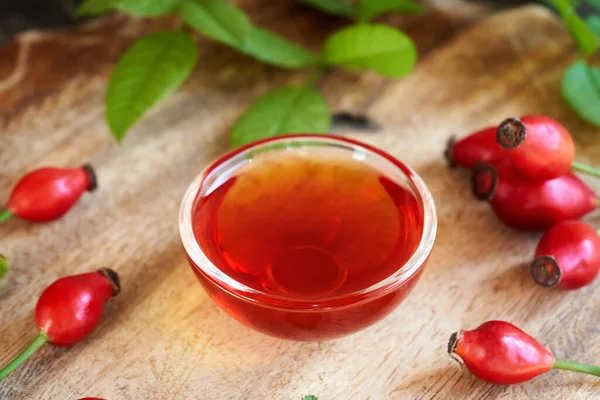 Hagebuttenkernöl Mit Frischen Beeren Und Blättern Auf Einem Tisch — Stockfoto