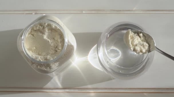 Βάζοντας Μια Κουταλιά Σκόνη Πρωτεΐνης Ορού Γάλακτος Ένα Ποτήρι Νερό — Αρχείο Βίντεο