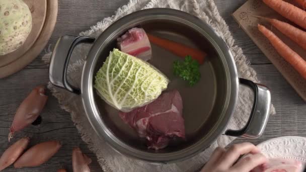 Frauenhände Legen Rindermarkknochen Einen Topf Mit Wasser Und Frischem Gemüse — Stockvideo