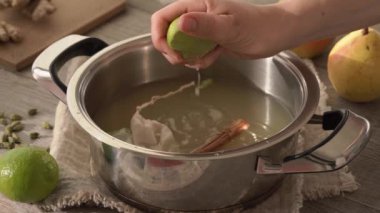 Ev yapımı sıcak armut içeceği hazırlamak. Meyve suyuna taze limon sıkmak, ağır çekim.