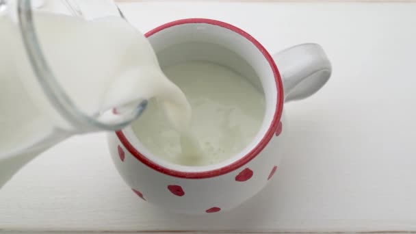 将鲜牛奶倒入小杯 慢动作 — 图库视频影像