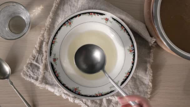 将自制的肉汤倒入有勺子的盘子或汤碗中 顶部看 — 图库视频影像