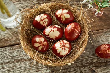 Paskalya yumurtaları soğan kabuklarıyla renklendirilir ve hasır sepette kar damlalarıyla süslenir.