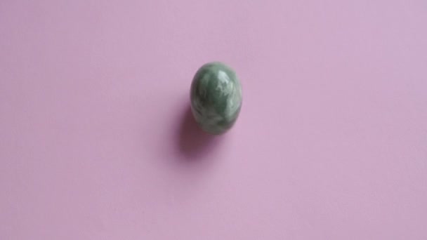 Green Jade Egg Spinning Pink Background Copy Space Slow Motion — Stock Video
