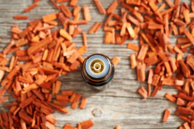 Bir şişe aromaterapi gerekli yağ ile kırmızı sandal ağacı parçaları, üst görünüm