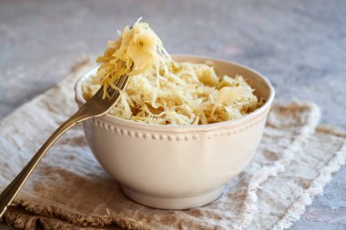 Ev yapımı mayalanmış lahana ya da lahana turşusu kasede ve çatalda.