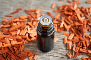 Aromaterapi masasında kırmızı sandal ağacı parçacıkları olan gerekli yağ